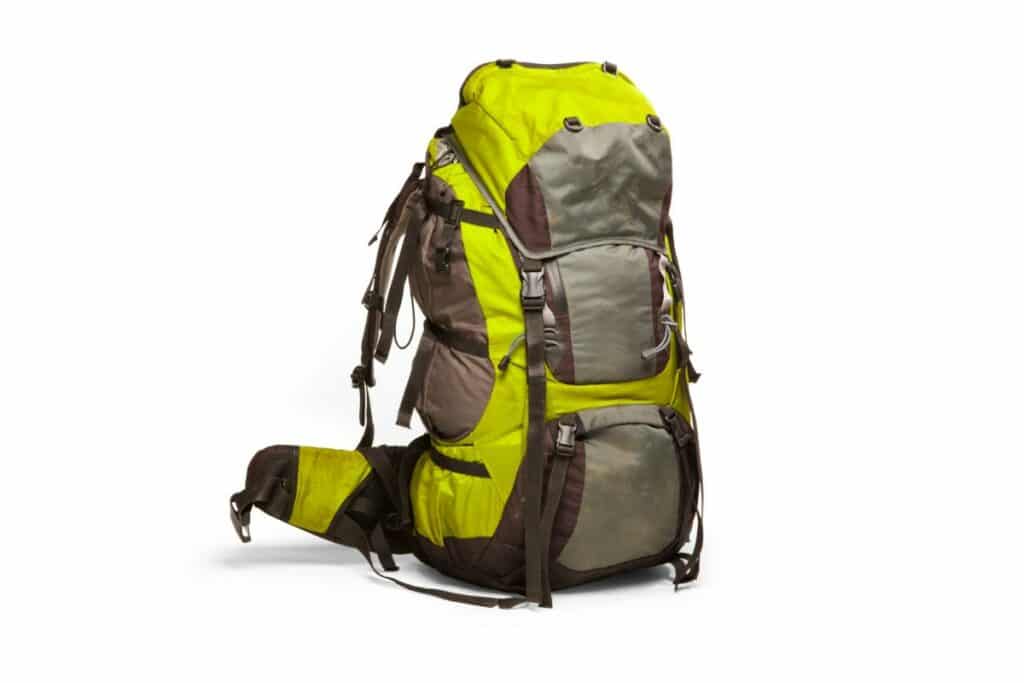 un sac de randonnée kaki et jaune est mis en avant sur un fond blanc. il possède diverses poches, fermetures et systèmes de sangles.